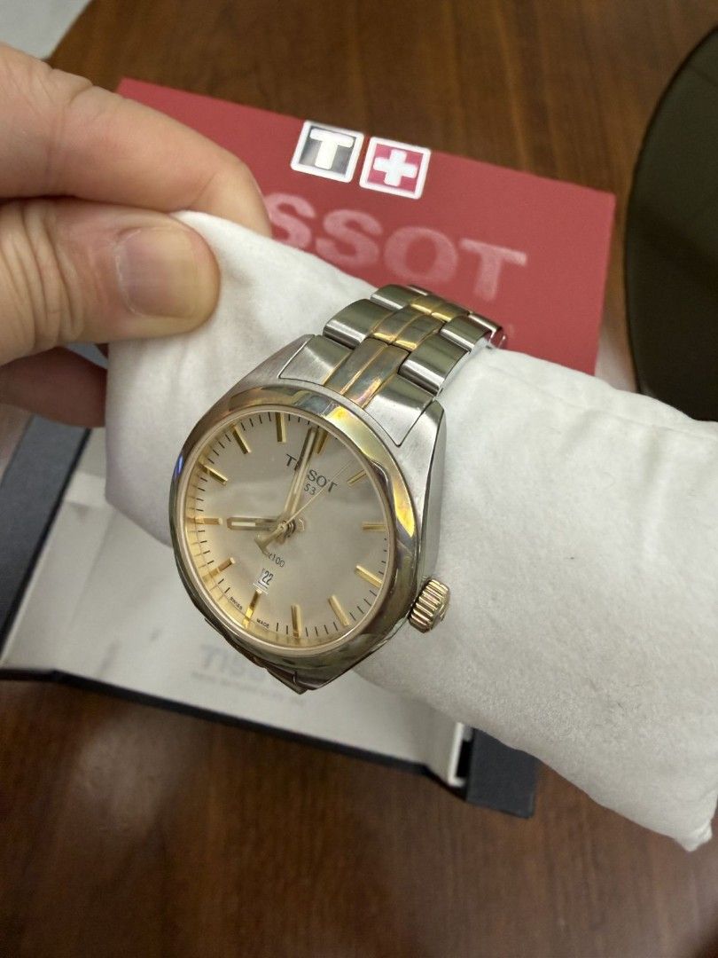 Tissot PR 100 Two-Tone Watch with Box (Category: Luxury Watches) located in Manila. Submitted by anythingbyjen (Listing ID 1470607691, Image 2). Description: - Authentic Tissot PR 100 wristwatch - Two-tone stainless steel and gold finish - Classic white dial with gold hands, index markers, and 6 o'clock date window - Secure folding clasp closure with iconic T logo - Includes original red and black Tissot presentation box - Condition: Shows visibl