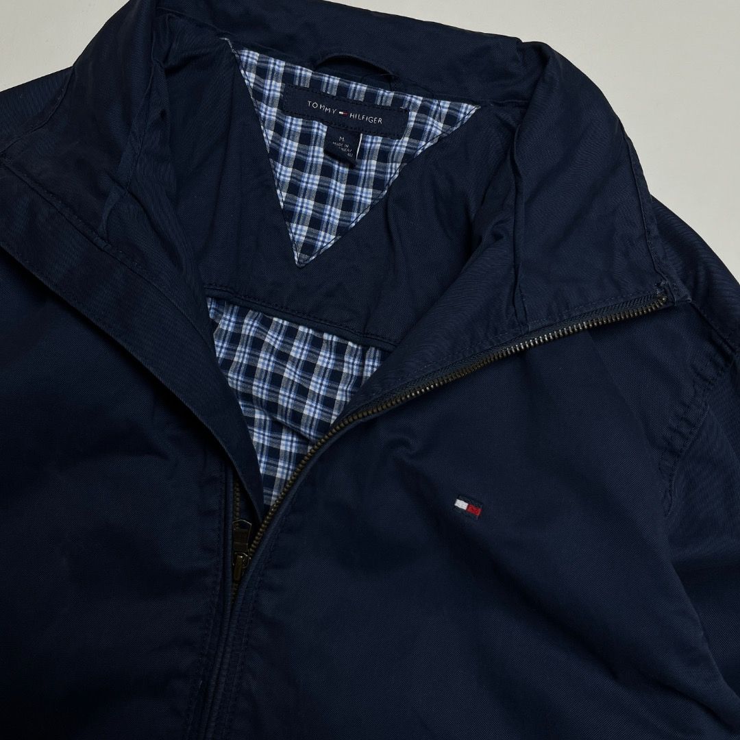 Tommy Hilfiger Harrington Jacket (Category: Coats, Jackets and Outerwear) located in Caloocan City. Submitted by achilles_grails (Listing ID 1470563577, Image 2). Description: - Brand: Tommy Hilfiger - Style: Harrington Jacket - Color: Classic Navy Blue - Lining: Blue and white checkered interior pattern - Details: Stand collar, full front zipper, signature embroidered flag logo on the chest - Condition: Excellent pre-owned condition with origina