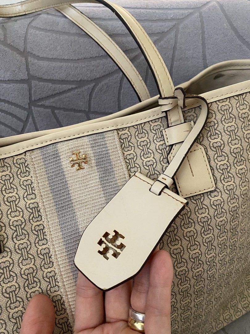 Tory Burch Beige Patterned Tote Bag (Category: Tote Bags) located in Calapan. Submitted by kimmieartsycraft (Listing ID 1470625580, Image 1). Description: - Brand: Tory Burch - Design: Cream and beige geometric chain pattern with an off-white and grey center stripe - Hardware: Gold-tone logo accent - Straps: Dual leather shoulder straps - Extras: Matching hanging luggage tag charm - Interior: Spacious, perfect for daily essentials - Style: Neutra