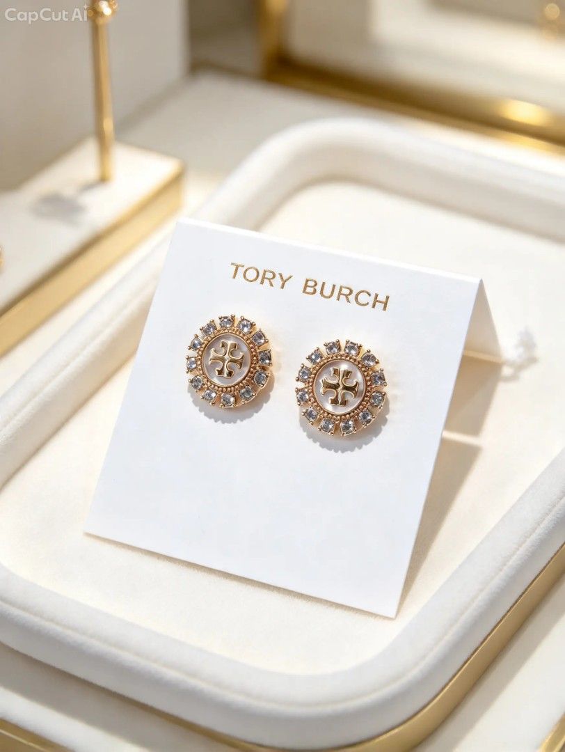 Authenthic 💯 Tory Burch Crystal Logo Stud Earrings (Category: Earrings) located in Naguilian. Submitted by jhoyukay (Listing ID 1470687579, Image 1). Description: - Authentic Tory Burch gold-tone stud earrings - Features a chic pearlized center surrounded by a sparkling crystal halo - Iconic Double T logo right in the middle - Condition: Brand new, never worn, still pinned to the original paper card - Inclusions: Comes with a branded dust bag an