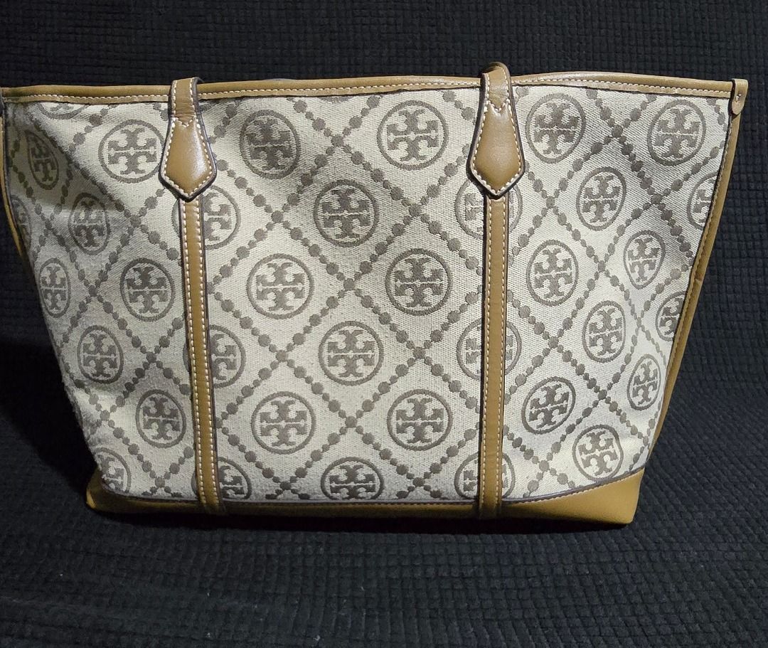 Tory Burch Monogram Tote Bag - Negotiable!!! (Category: Tote Bags) located in Manila. Submitted by axelyuna.27 (Listing ID 1470586201, Image 2). Description: Authentic Tory Burch tote in beige and brown canvas with tan leather trim. Features a structured base, gold-tone logo charm, and clean exterior. Interior shows normal signs of use and discoloration. Perfect everyday bag with classic monogram style!.