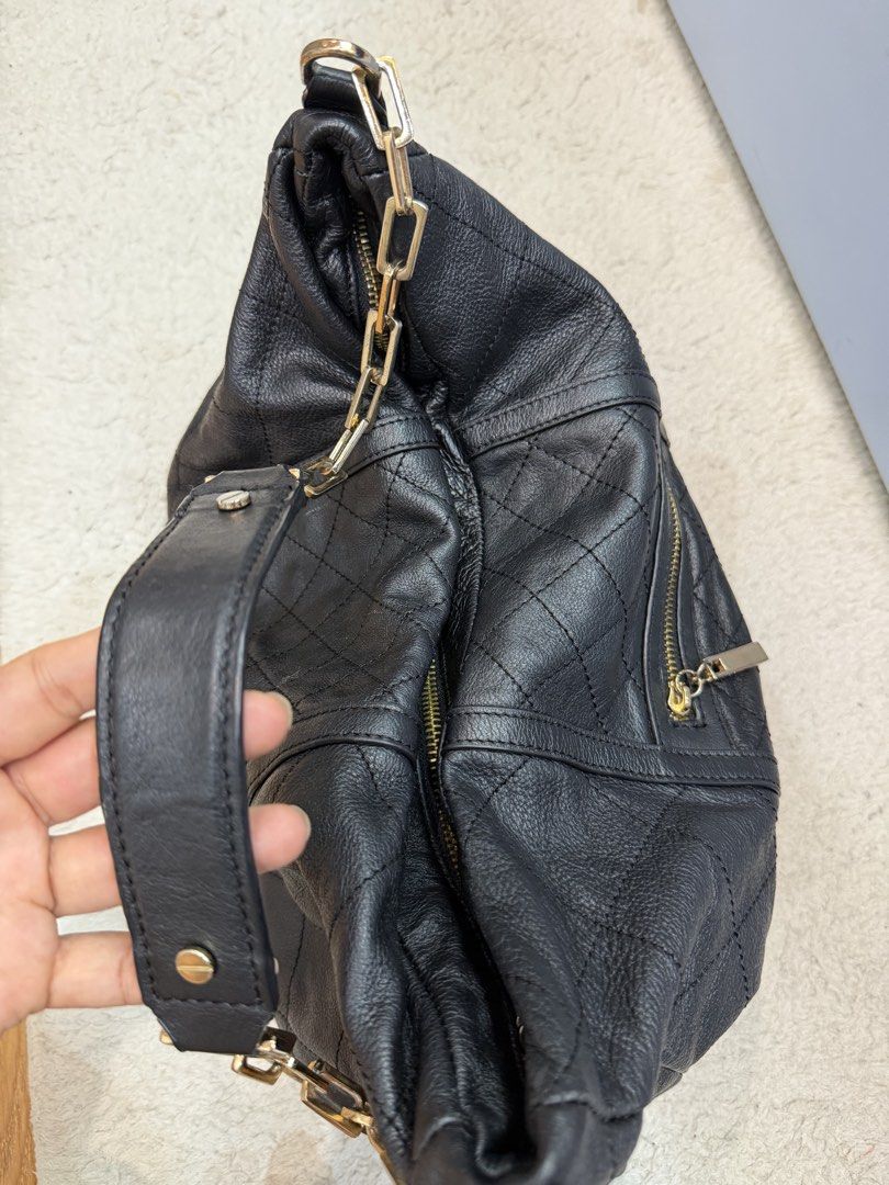 Tory Burch Shoulder Bag (Category: Shoulder Bags) located in Rizal. Submitted by myleb.finds (Listing ID 1470594039, Image 2). Description: 🖤 **A LITTLE EDGE. A LOT OF STYLE.** ✨ Not your ordinary black bag! 👜 This beauty brings together a relaxed slouchy silhouette, edgy gold chain details, and that effortlessly chic vibe we all love. 🖤✨ For the girl who loves style with a little attitude. 😉🤎 Would you rock this look? ♡ 📩 DM us for the pri