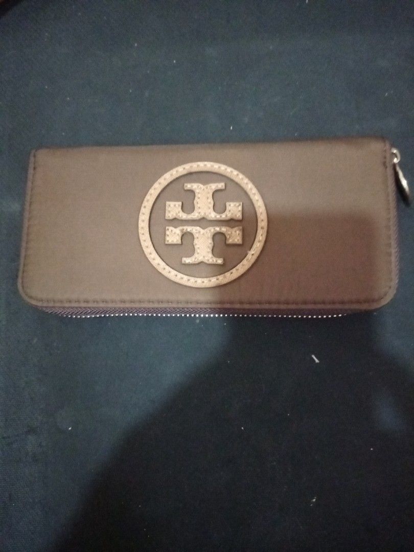Tory Burch Zip Around Long Wallet Brown (Category: Wallets & Card holders) located in Manila. Submitted by luckyeagle-7ff8 (Listing ID 1470590431, Image 2). Description: - Brand: Tory Burch - Color: Brown with light brown circular T logo - Hardware: Gold-tone with engraved logo zipper pull - Closure: Zip-around - Interior: Multiple compartments and zipped coin pocket for cash and cards - Condition: Well-maintained and 100% authentic.