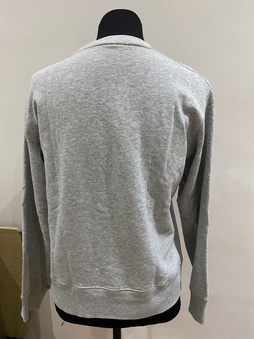 UNIQLO Grey Sweatshirt Size 160 (Category: Coats, Jackets and Outerwear) located in Manila. Submitted by mpt99876 (Listing ID 1470596491, Image 3). Description: - Brand: Uniqlo - Color: Solid grey - Size: 160 - Style: Classic crew neck with V-stitch detail - Features: Ribbed collar, cuffs, and hem, long sleeves - Condition: Clean fabric, no stains or damage.