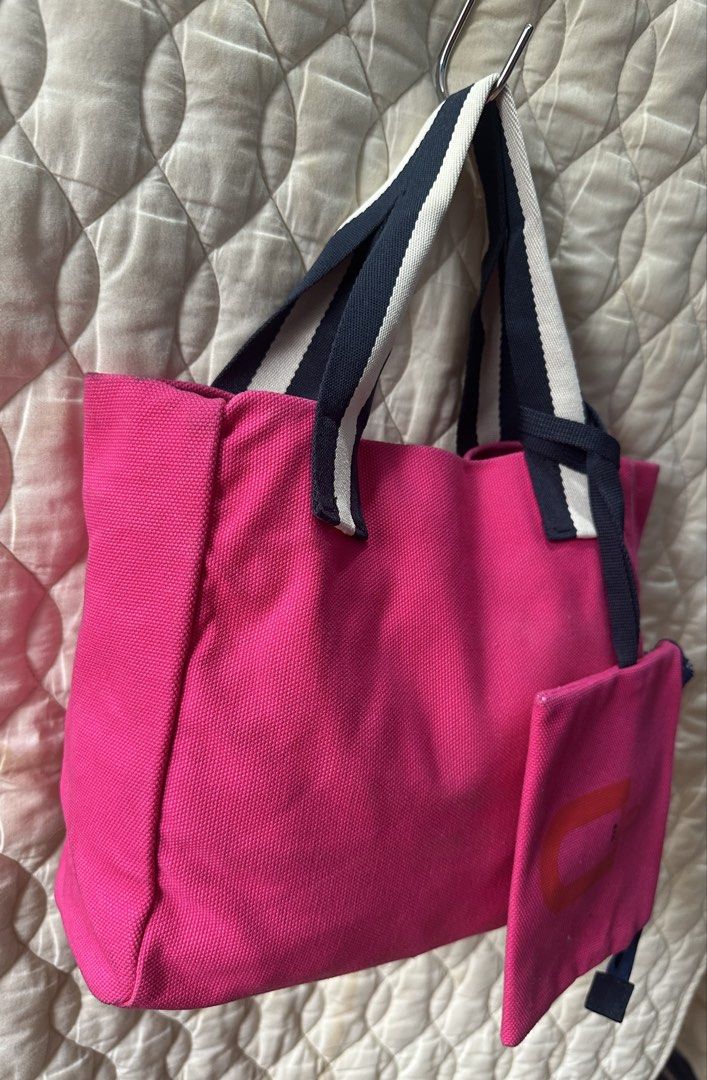 Uniqlo U Canvas Hand Bag Pink (Category: Tote Bags) located in Santa Rosa. Submitted by esplanamur03635 (Listing ID 1470689130, Image 2). Description: - Brand: Uniqlo U - Color: Bright pink canvas with navy and white striped handles - Includes: Matching zippered pouch attached with a strap wide room - Interior: Open top organizational slip pockets along the sides - Material: Sturdy denim like fabric - Size: Practical carryall size, perfect for da
