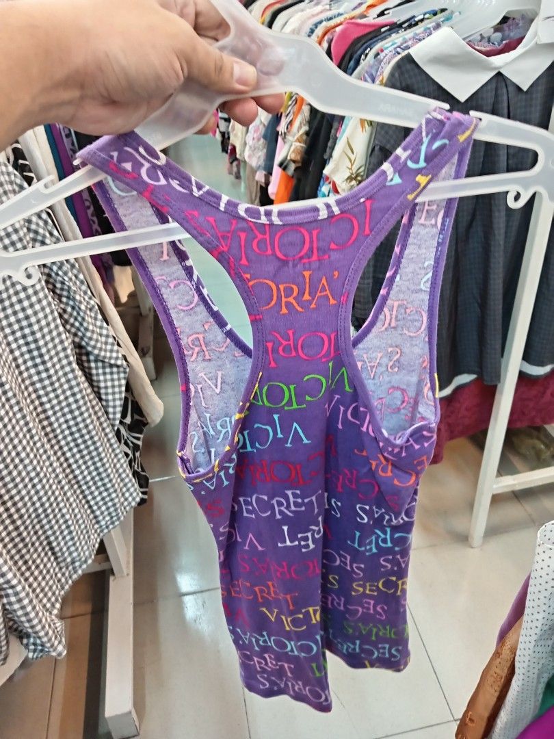 Victoria's Secret (Category: Sleeveless) located in Manila. Submitted by sonny2k (Listing ID 1470678157, Image 2). Description: - Brand: Victoria's Secret PINK - Color: Purple with all-over colorful logo print - Style: Racerback with scoop neck - Size: Small - Material: 100% Cotton (soft & breathable) - Condition: Great for casual everyday wear.