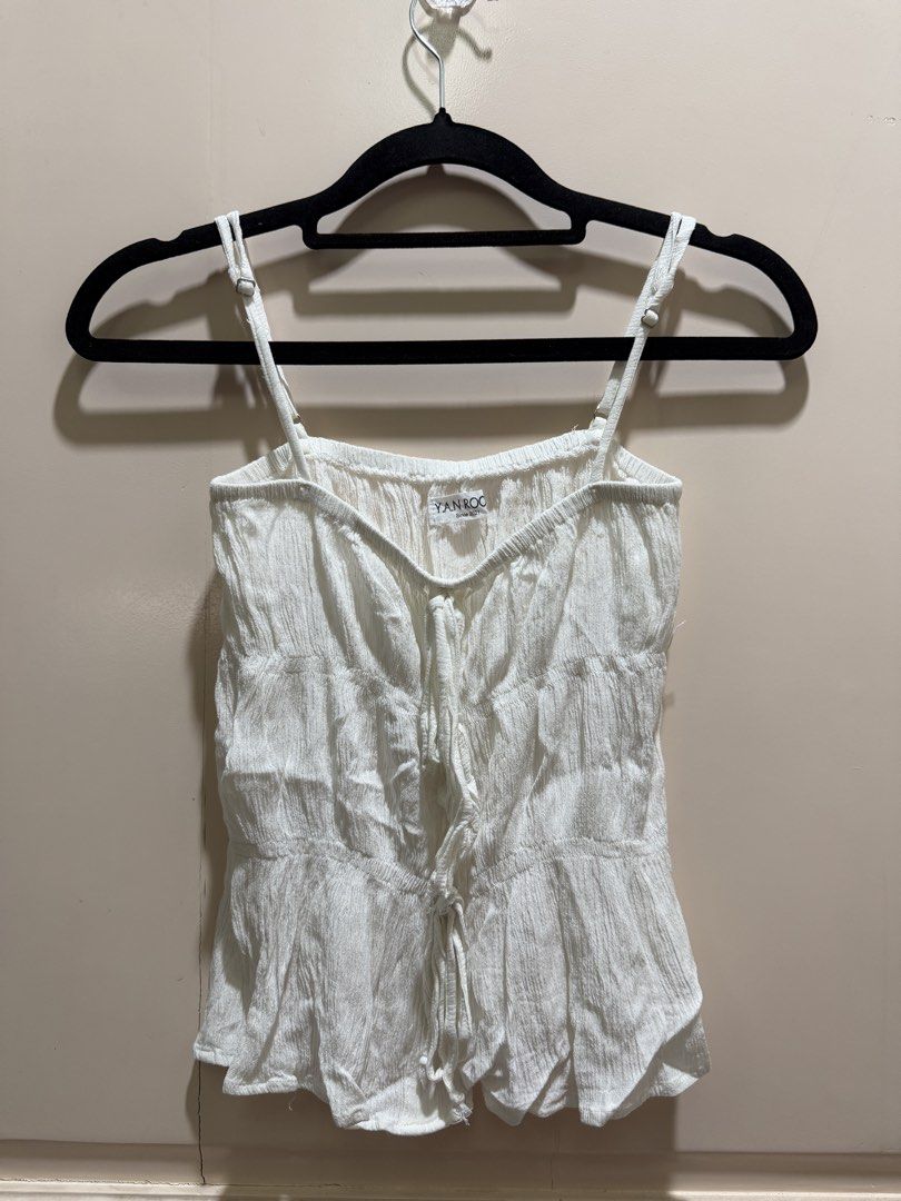 Vietnam White Ruched Tie-Front Cami Top (Category: Sleeveless) located in Davao. Submitted by 2ndbase.dvo.ii (Listing ID 1470597014, Image 2). Description: - Brand: YAN.ROO - Color: White - Material: Lightweight textured crinkle fabric - Design: Adjustable spaghetti straps, multi-tie front closure, and peplum hem - Perfect for warm weather and easily pairs with jeans or skirts.