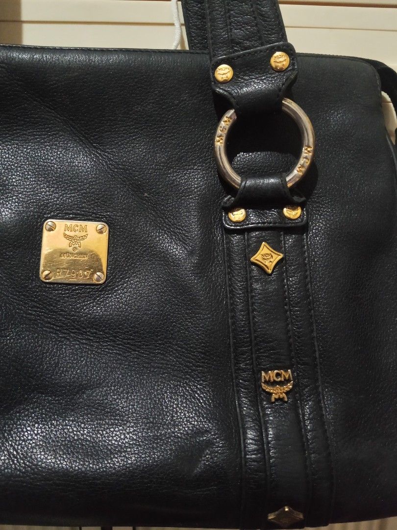 Vintage Authentic MCM Black Leather Tote Shoulder Bag. RUSH SALE (Category: Luxury Bags & Wallets) located in Adams. Submitted by red__lee (Listing ID 1470672097, Image 3). Description: Feel free to message me if you have any questions :>> -No broken zippers -Clean interior/no issues Flaws to note: • Leather piping on the bottom corners is split/exposed. • Normal vintage corner rubs, surface scuffs, and slight color fading. • Gold hardware shows 