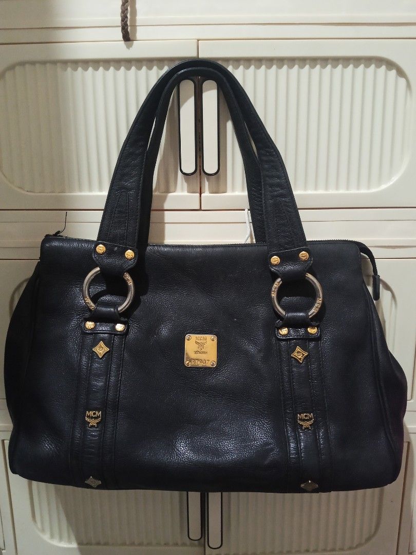 Vintage Authentic MCM Black Leather Tote Shoulder Bag. RUSH SALE (Category: Luxury Bags & Wallets) located in Adams. Submitted by red__lee (Listing ID 1470672097, Image 1). Description: Feel free to message me if you have any questions :>> -No broken zippers -Clean interior/no issues Flaws to note: • Leather piping on the bottom corners is split/exposed. • Normal vintage corner rubs, surface scuffs, and slight color fading. • Gold hardware shows 
