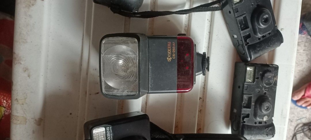 Vintage Cameras and Flash Units Lot (Category: Cameras) located in Taguig. Submitted by grandfish_55ab5c (Listing ID 1470735746, Image 1). Description: - Bundle of vintage photography gear straight from storage - Includes Fujifilm Smart Shot film camera, Fujifilm FinePix A201 digital camera, Kyocera CS-250 AF flash, and Minolta Program D 314i flash - Comes with extra camera bodies and parts for repair or display - Untested condition, sold as-is -