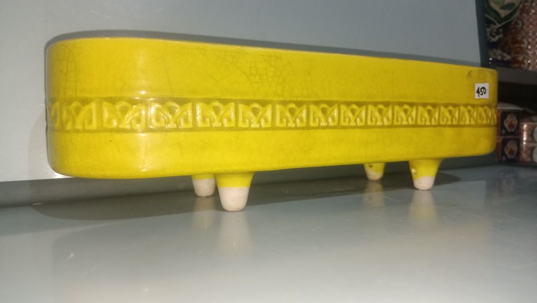 Vintage Ikebana yellow rectangular ceramic planter pot with footed base (Category: Pots & Planters) located in Munoz. Submitted by larryc1212 (Listing ID 1470630218, Image 1). Description: - Color: Bright yellow ceramic with a textured geometric pattern - Shape: Rectangular with rounded ends, raised on 4 white feet - Size: Approx. 16 inches long and 4.25 inches deep - Condition: Good solid piece with normal glaze crazing - Versatile: Perfect for 