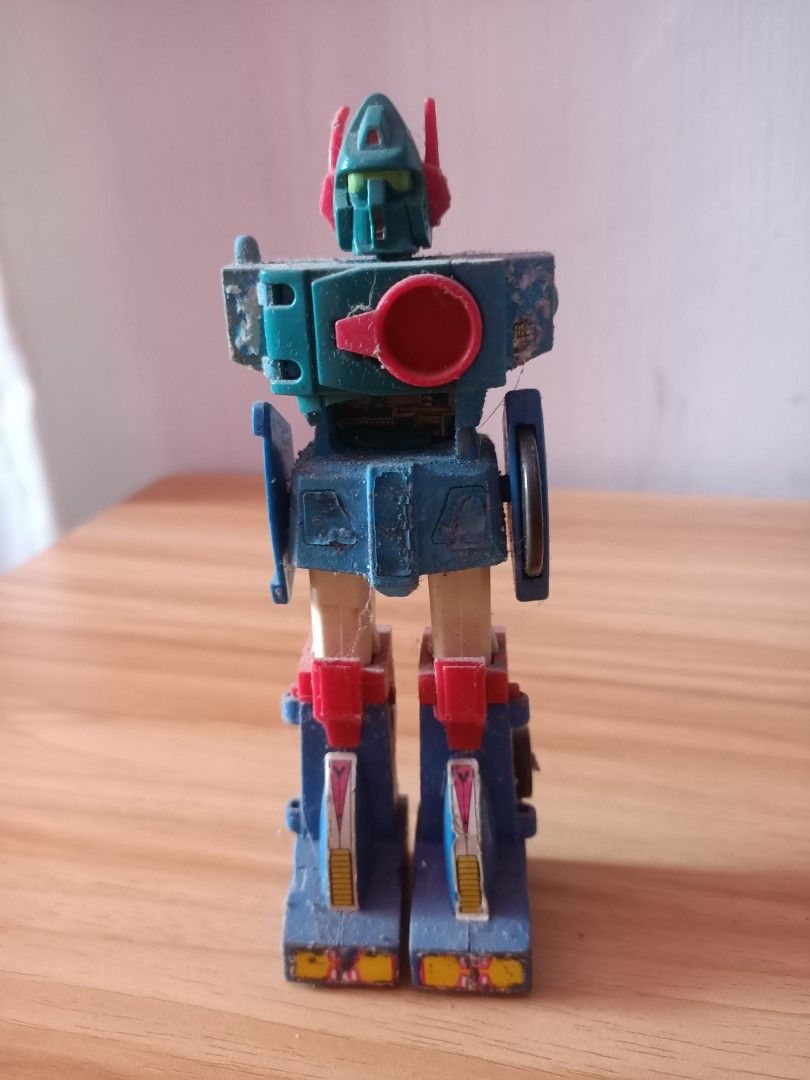 Vintage Retro Transforming Robot Action Figure (Category: Action & Battle Toys) located in Taguig. Submitted by grandfish_55ab5c (Listing ID 1470565559, Image 3). Description: - Vintage multi-colored transforming robot action figure - Features classic mechanical styling with movable parts - Shows minor dust, paint chipping, and surface wear from long-term storage - Perfect collectible display piece for retro toy enthusiasts - PM for more details 