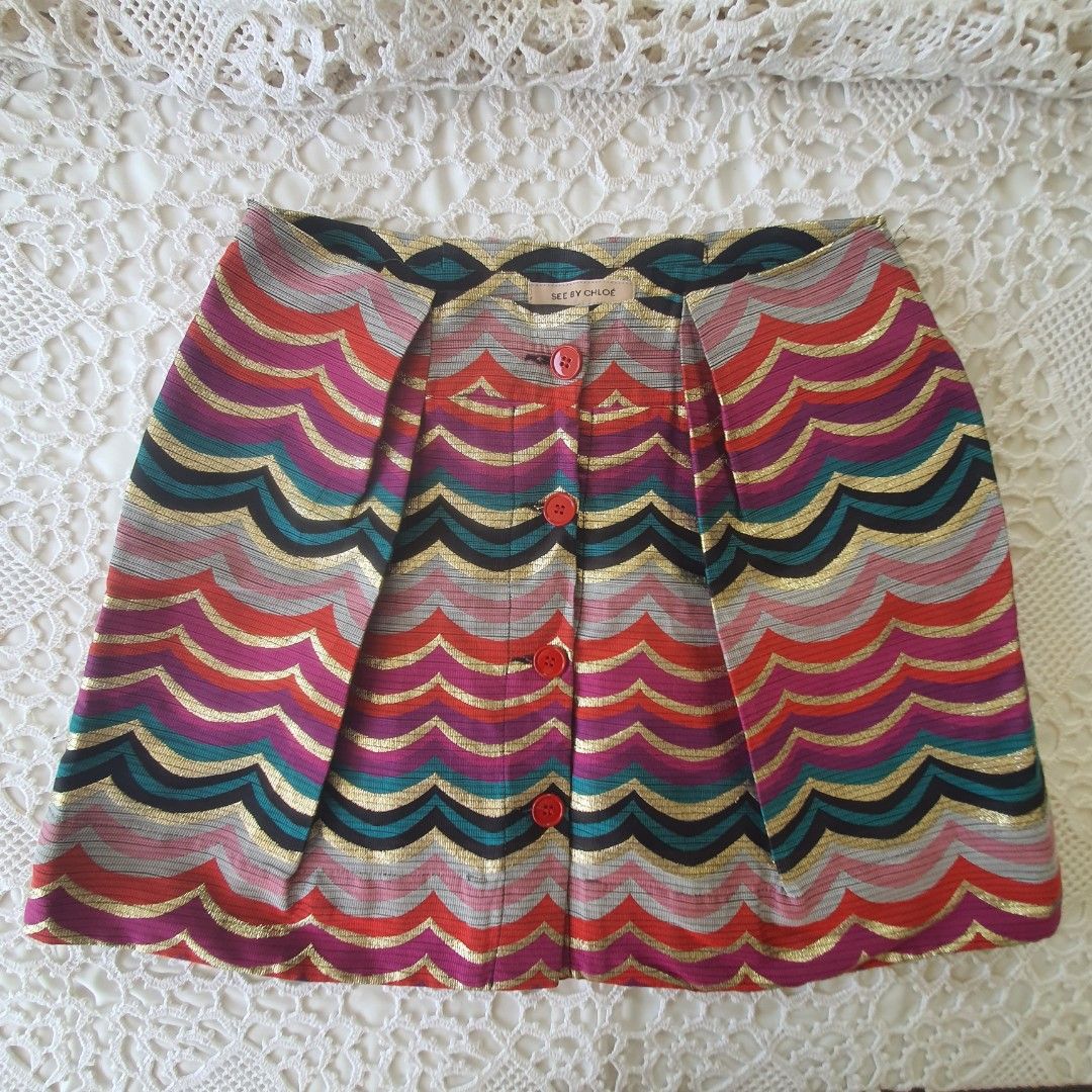 Vintage See By Chloe Chevron Pattern Mini Skirt (Category: Skirts) located in Laoag. Submitted by soukay (Listing ID 1470582920, Image 1). Description: - Brand: See By Chloé - Style: Fun retro mini skirt with a colorful chevron zigzag pattern - Details: Metallic gold threads throughout and striking red front buttons - Origin: Made in Serbia - Care: Dry clean only - Condition: Excellent statement piece.