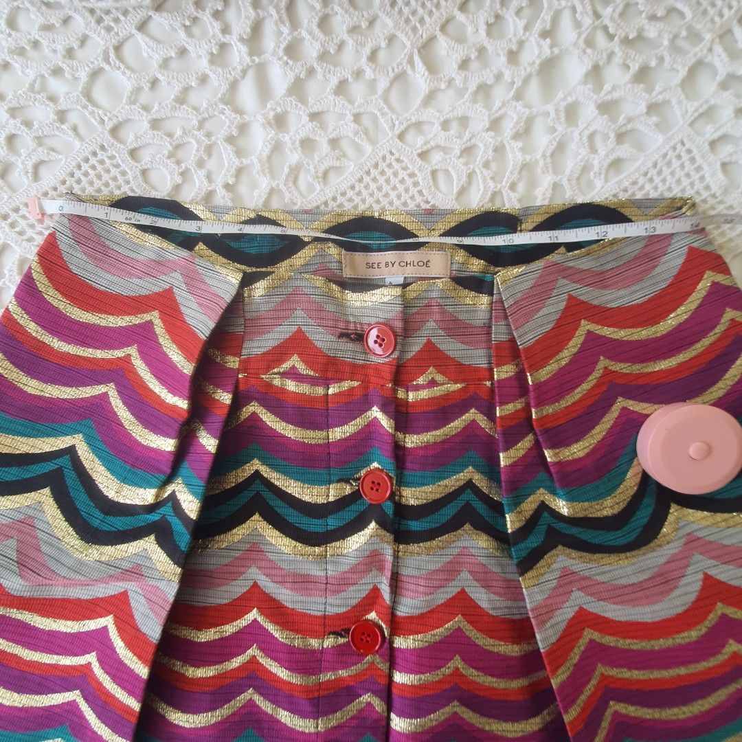 Vintage See By Chloe Chevron Pattern Mini Skirt (Category: Skirts) located in Laoag. Submitted by soukay (Listing ID 1470582920, Image 3). Description: - Brand: See By Chloé - Style: Fun retro mini skirt with a colorful chevron zigzag pattern - Details: Metallic gold threads throughout and striking red front buttons - Origin: Made in Serbia - Care: Dry clean only - Condition: Excellent statement piece.