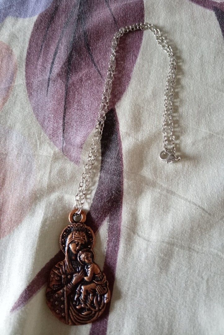 Virgin Mary and Child Copper Pendant Necklace (Category: Necklaces) located in Quezon City. Submitted by chacha30.s (Listing ID 1470651069, Image 3). Description: - Copper-tone pendant featuring the Virgin Mary and Baby Jesus - Back engraved with Romanian inscription: "PREA SFÂNTA NĂSCĂTOARE DE DUMNEZEU MILUIEŞTE-NĂ PRE MINE PĂCĂTOSUL" - Comes with a silver-tone link chain and secure lobster clasp - Lightweight metal design for comfortable everyd