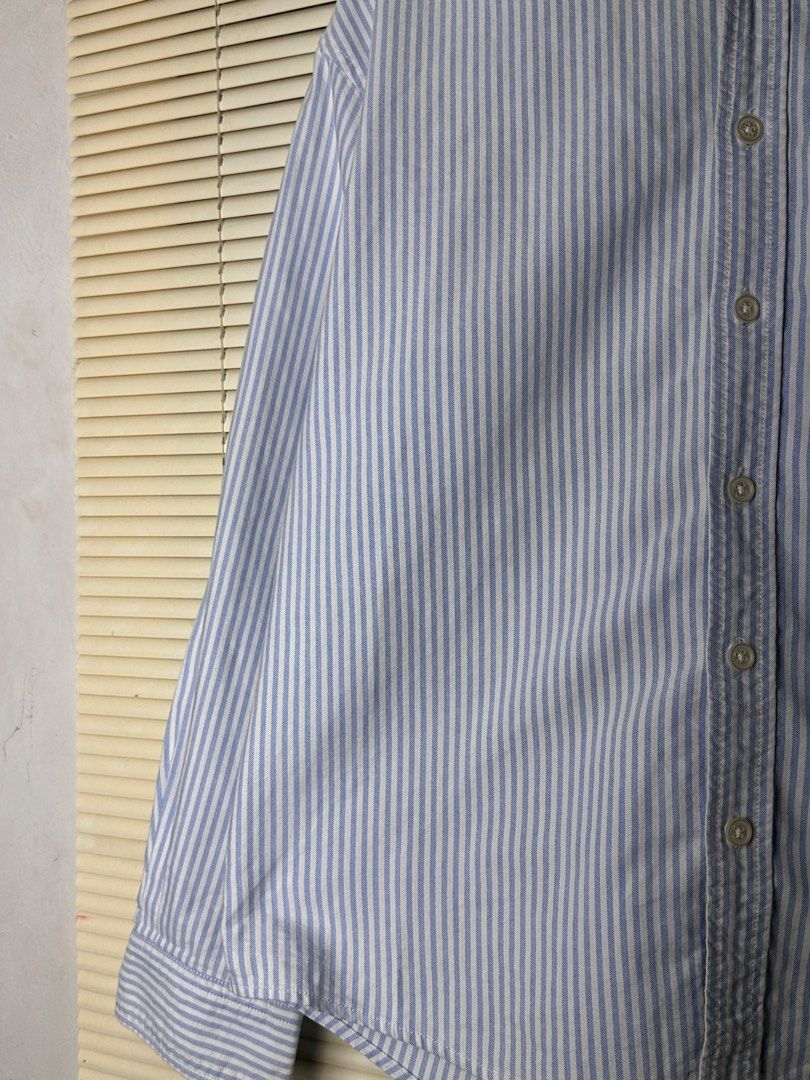 Wassup Blue and White Striped Button-Up Shirt (Category: Coats, Jackets and Outerwear) located in Santa Rosa. Submitted by shop818 (Listing ID 1470697982, Image 3). Description: Light blue and white vertical stripe shirt from Wassup. Collared neckline, button-down front, and a single chest pocket featuring a small brand logo label. Long sleeves with button cuffs. Back yoke has a small embroidered graphic detail and locker loop. Lightweight cotton