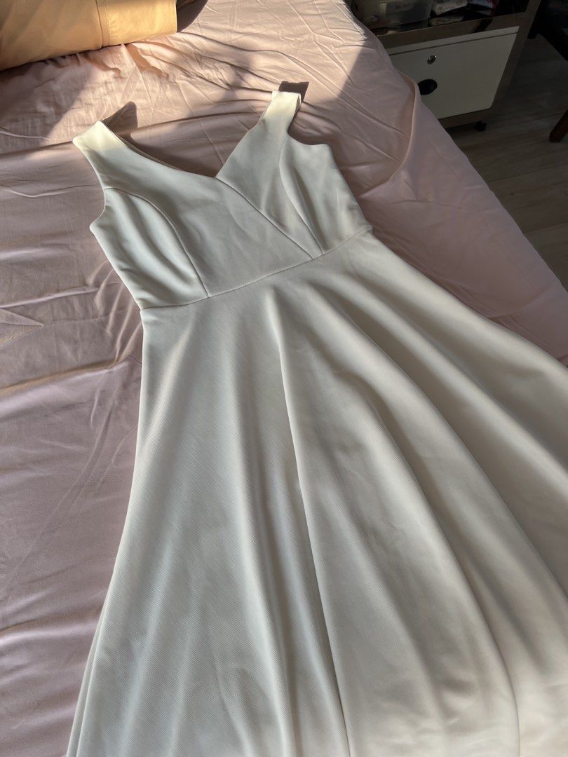 White Asymmetrical Dress (Category: Dresses) located in Manila. Submitted by bye.ad (Listing ID 1470666586, Image 1). Description: - Color: White - Design: Sleeveless with a V-neck, fitted bodice, and flared skirt - Fabric: Structured material with a stylish visible texture - Quality: Clean seams and neatly finished edges - Styling: Perfect for everyday wear or semi-formal occasions; pairs well with both heels and flats.