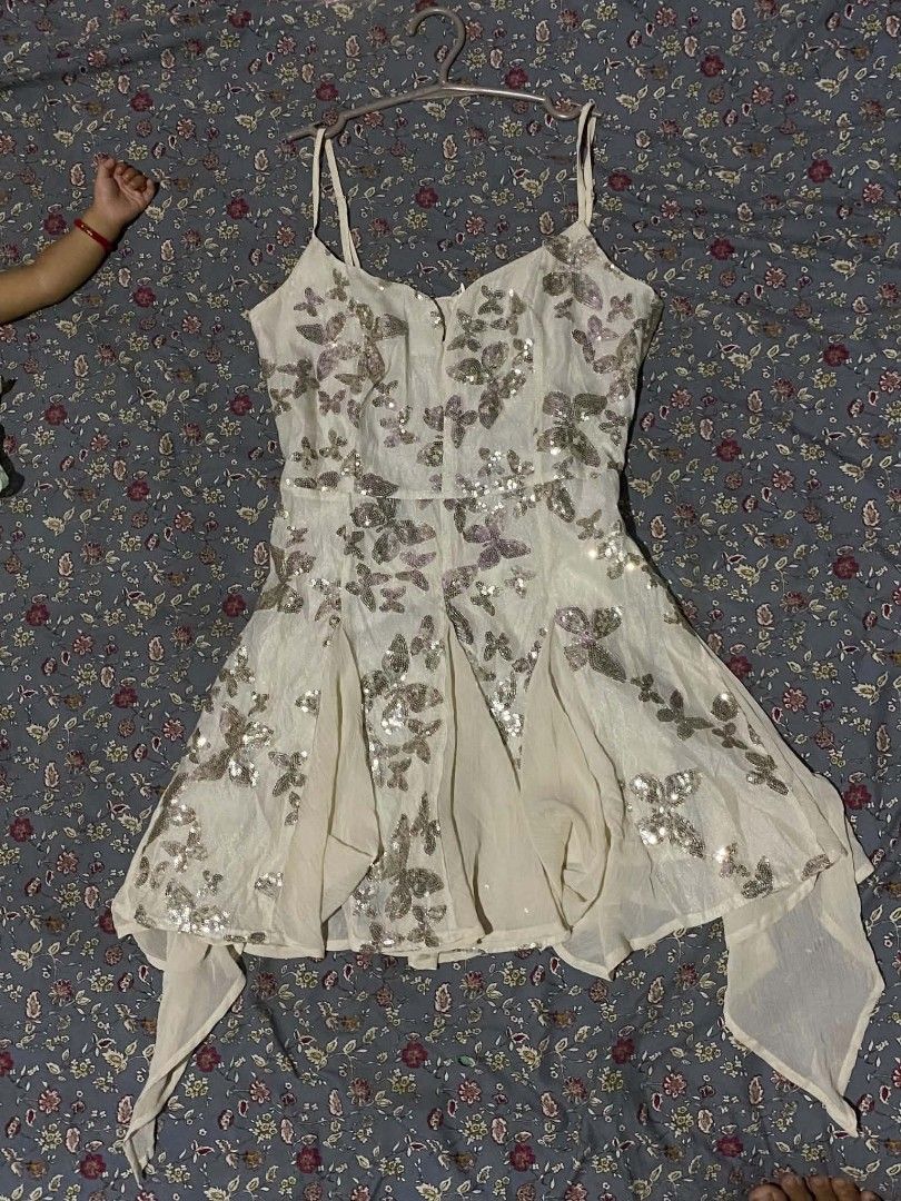 White butterfly sequin spaghetti strap sundress (Category: Dresses) located in Tarlac. Submitted by fastdragon_d1826f (Listing ID 1470670094, Image 1). Description: - Style: White sleeveless mini dress with spaghetti straps - Design: All-over shiny sequin butterflies and floral motifs - Fit & Cut: Fitted bodice with a flared, uneven hemline and side draped panels - Material: Lightweight and eye-catching fabric that sparkles in the light - Closure