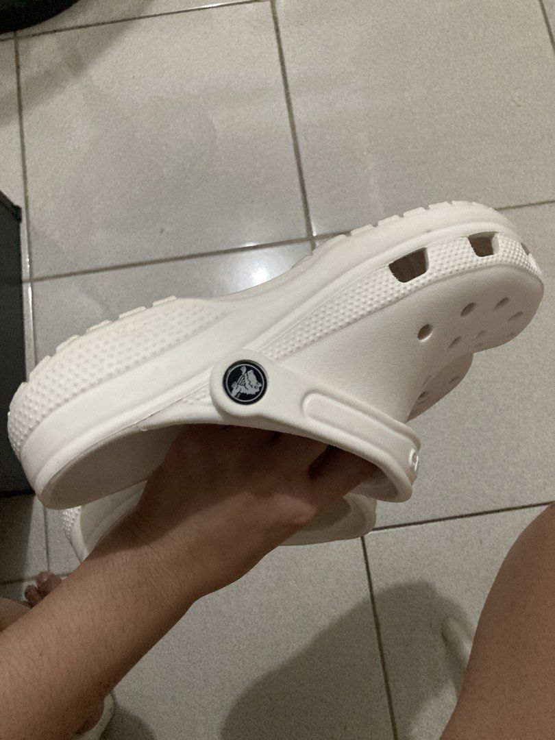 White Crocs Classic Clogs (Category: Slippers and slides) located in Pasay City. Submitted by daisuki.x0x0 (Listing ID 1470655916, Image 3). Description: - Item: Classic White Crocs Clogs - Size: J6 - Condition: Minor wear on bottom treads from normal use - Features: Slip-on design, top ventilation holes, adjustable heel strap with logo rivets - Origin: Made in Vietnam - Perfect for daily casual wear, school, or errands.