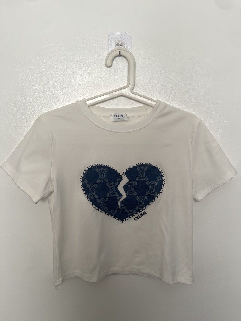 White Crop Top With Blue Broken Heart Design (Category: Shirts) located in Manila. Submitted by lovedbymidge (Listing ID 1470644919, Image 1). Description: 🩷 for s-m girlies 🚚 lalamove or grab express (sf shouldered by the buyer!) - Style: Short sleeve crop top - Color: White - Details: Dark blue denim-look broken heart graphic patch with visible stitching and small Celine branding - Condition: Brand new, never worn, clean fabric.