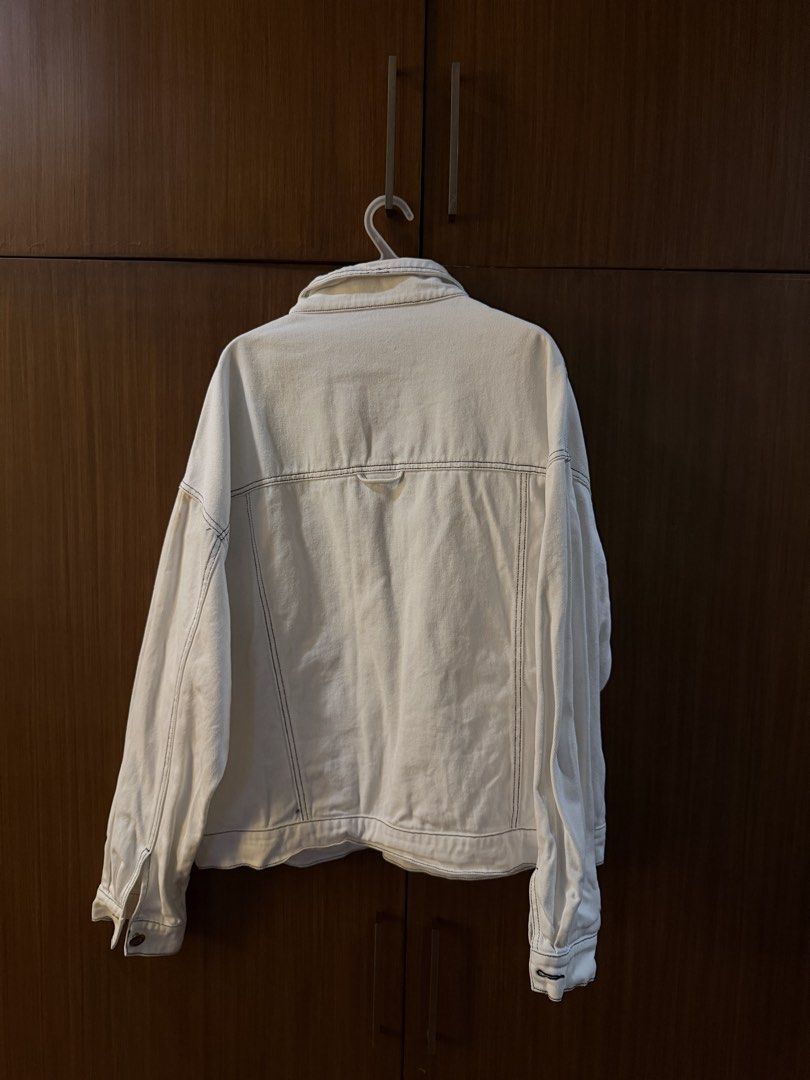 White denim jacket with contrast stitching (Category: Coats, Jackets and Outerwear) located in Paranaque City. Submitted by preloveditems111 (Listing ID 1470715134, Image 2). Description: - Color: White denim with striking dark contrast stitching - Fit: Oversized and relaxed silhouette - Design: Classic button-up front with chest flap and side welt pockets - Style: Versatile outerwear perfect for casual everyday looks.