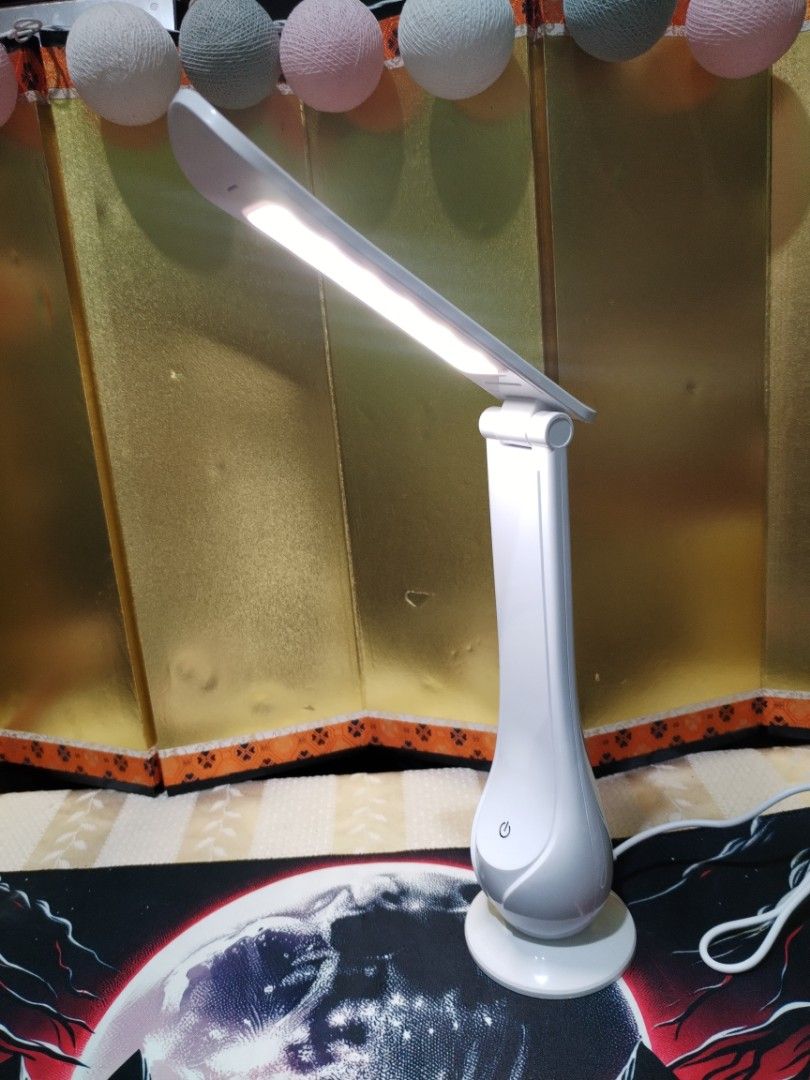 White Foldable LED Desk Lamp USB Powered (Category: Lighting) located in La Trinidad. Submitted by malditas (Listing ID 1470705287, Image 1). Description: - Compact white LED desk lamp with a clean, modern look - Convenient touch control power button on the front base - Adjustable head and foldable arm for custom lighting angles - USB-powered (cable included/plugs into the back base) - Folds completely flat for easy storage and space-saving From 