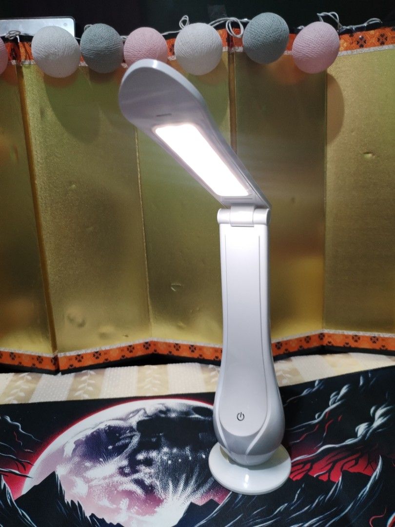 White Foldable LED Desk Lamp USB Powered (Category: Lighting) located in La Trinidad. Submitted by malditas (Listing ID 1470705287, Image 3). Description: - Compact white LED desk lamp with a clean, modern look - Convenient touch control power button on the front base - Adjustable head and foldable arm for custom lighting angles - USB-powered (cable included/plugs into the back base) - Folds completely flat for easy storage and space-saving From 