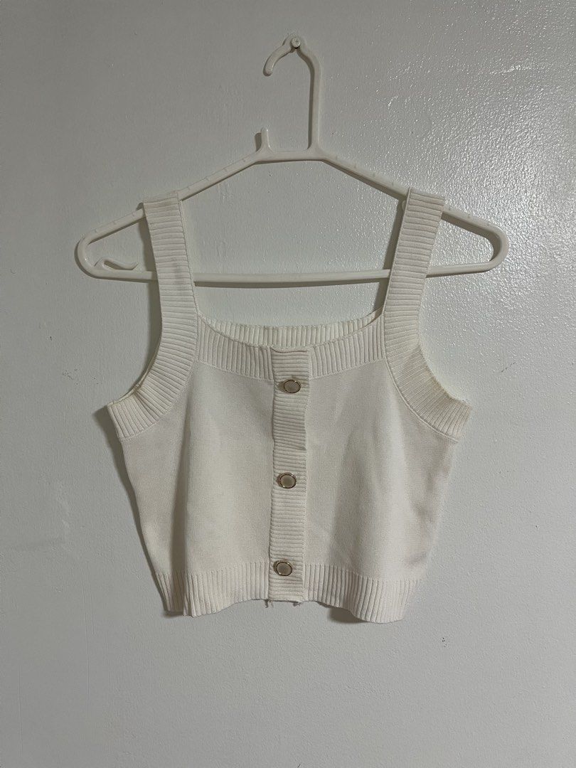 White Knitted Crop Tank Top with Buttons (Category: Sleeveless) located in Cabuyao City. Submitted by rdtrmt (Listing ID 1470743054, Image 1). Description: - Color: White - Style: Knitted crop top with square neckline and wide straps - Details: Front button closure with three metallic-rimmed buttons and ribbed trim - Fabric: Soft textured knit - Fit: Versatile basic piece, great for layering or wearing on its own - Pairing: Easily matches high-wa
