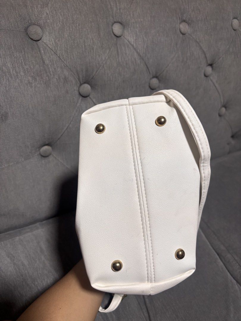 White Ruched Handle Shoulder Bag With Gold Hardware (Category: Luxury Bags & Wallets) located in Manila. Submitted by alyanarein (Listing ID 1470723306, Image 2). Description: White faux leather shoulder bag. Unique ruched gathered handles on both sides. Gold tone bottom feet protect the base. Removable crossbody strap included. Clean grey interior lining with open main compartment. Compact size fits daily essentials easily. Simple chic style goe