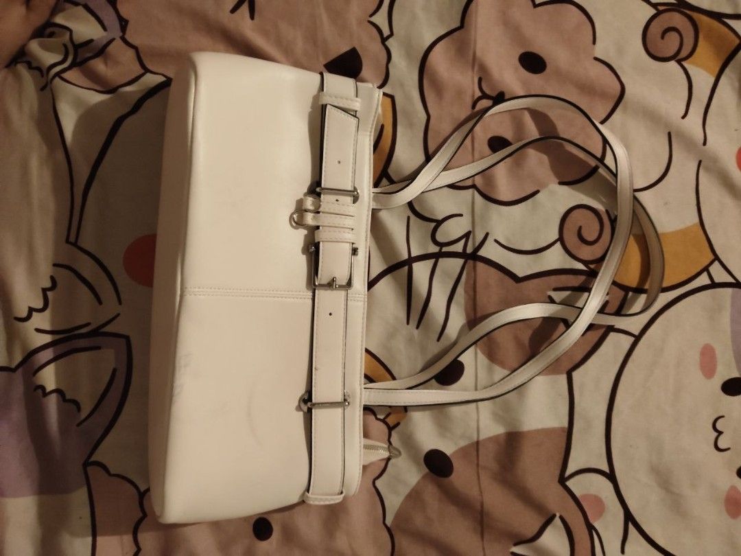 White shoulder bag with buckle strap detail (Category: Shoulder Bags) located in Bacoor. Submitted by ksyoungieberries (Listing ID 1470703990, Image 1). Description: - Style: Modern minimalist shoulder bag - Material: Premium white faux leather - Design: Structured boxy shape with vertical seam stitching - Details: Wraparound strap with silver-tone side buckles - Straps: Dual slim shoulder straps - Size: Compact and perfect for everyday use.
