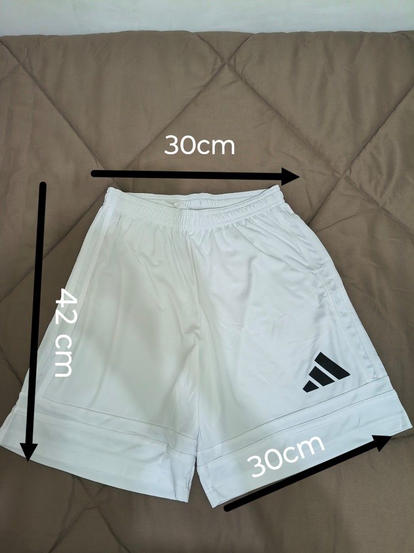 White Sports Shorts (Category: Activewear) located in Mandaluyong City. Submitted by yeojdurangorecto (Listing ID 1470630840, Image 1). Description: - Brand: Adidas - Color: White with black logo on lower right leg - Material: Lightweight fabric, ideal for workouts and casual wear - Waist: Elastic waistband with adjustable drawstring - Measurements: 30cm waist width, 42cm length, 30cm leg opening - Condition: Excellent RUSH ITEM!!! ONE PIECE ONLY