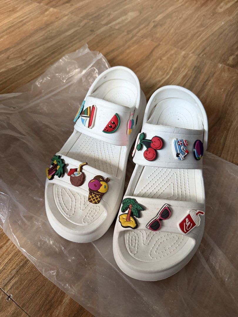 White Summer Sandals with Charms Size 40 (Category: Flats & Sandals) located in Tanza. Submitted by calmwind_2a9316 (Listing ID 1470639422, Image 2). Description: - Style: Slip-on white platform sandals with chunky rubber sole and grip pattern - Details: Decorated with cute summer charms (palm trees, watermelon, ice cream, sunglasses) - Size: 40 (marked on sole) - Condition: Brand new, unworn, and kept in original plastic packaging.