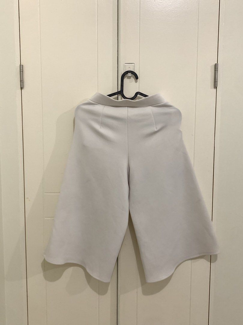 White Wide Leg Culottes Cropped Pants (Category: Jeans) located in Pasig City. Submitted by lovedbyri (Listing ID 1470652854, Image 2). Description: - Color: White - Style: Wide leg cropped pants - Features: Two front pockets, subtle back darting for a flattering fit - Fabric: Structured material that holds its shape well - Versatility: Easy to match with both casual tees and dressy blouses.