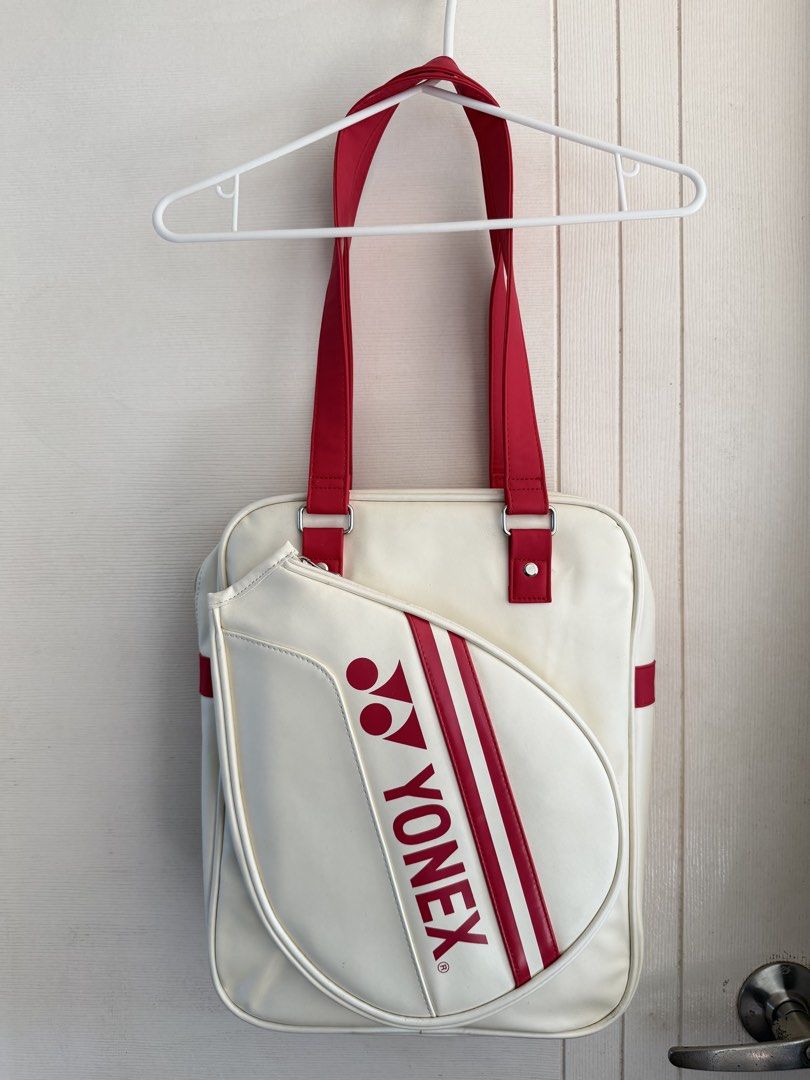 Yonex Badminton Bag White and Red (Category: Racket and Ball Sports) located in Manila. Submitted by cinnmoroll (Listing ID 1470608295, Image 2). Description: Yonex badminton bag in white with red straps and accents. Classic racket-shaped front pocket design with large printed Yonex branding. Used twice only, practically spotless inside and out. Dual shoulder straps for easy carry to the court. Sturdy material keeps gear protected..