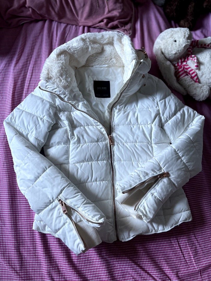 Zara Basic White Puffer Jacket with Faux Fur Hood (Category: Coats, Jackets and Outerwear) located in Manila. Submitted by jhenniegir36703 (Listing ID 1470634179, Image 3). Description: - Brand: Zara Basic - Color: White - Style: Quilted puffer jacket with high collar - Details: Fluffy faux fur lining on the collar, rose gold zippers on front and cuffs - Condition: Great, clean with no stains or damage - Perfect for cold weather.