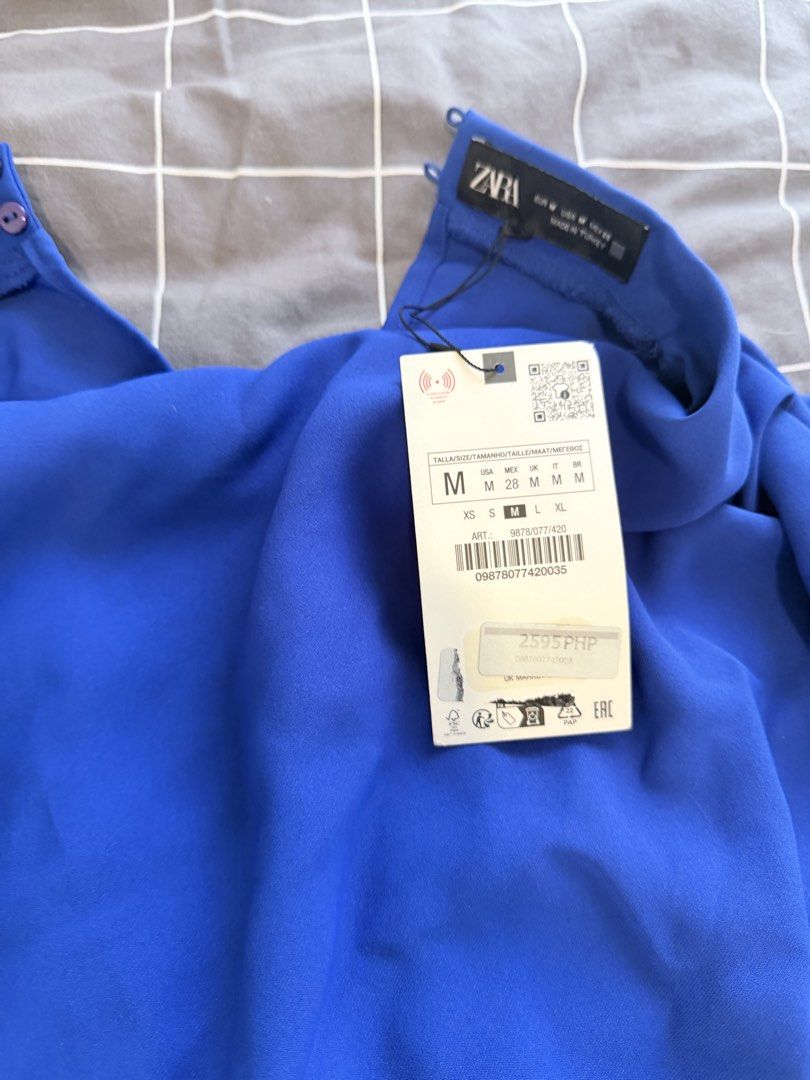 Zara Royal Blue Draped Dress (Category: Dresses) located in Makati City. Submitted by purewind.a22dcd (Listing ID 1470594167, Image 3). Description: - Brand: Zara (Brand tag and original store tags still attached) - Color: Bright royal blue - Style: Sleeveless with gathered front draping and a flowy fit - Details: Unique silver-tone accent ring at the waistline and back collar button closure - Condition: Brand new, never worn.