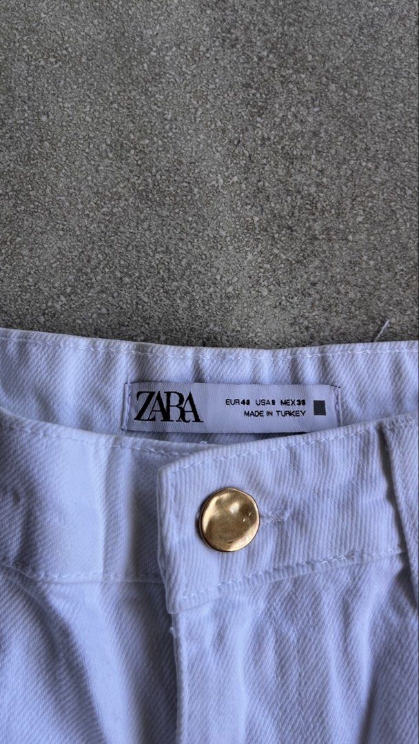 Zara White Denim Jeans Size EUR 40 (Category: Jeans) located in Cabuyao City. Submitted by bulandos (Listing ID 1470656739, Image 3). Description: - Brand: Zara - Item: White denim jeans with wide-leg fit and raw hem details - Size: EUR 40 / USA 8 / MEX 30 - Hardware: Gold-toned metal button closure - Origin: Made in Turkey - Condition: Good, with minor faint yellowish spots on one of the pant legs.