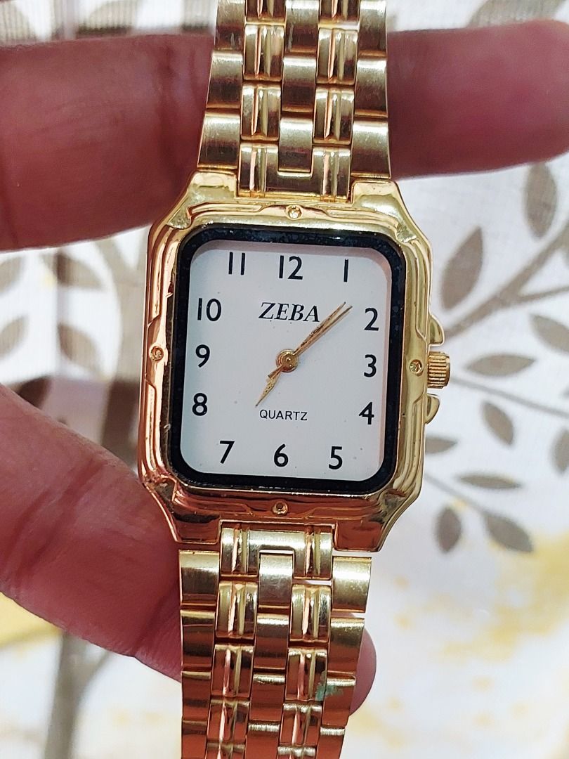 ZEBA Gold Quartz Watch with Rectangular Dial (Category: Women's Watches) located in Batangas. Submitted by vintageanddainty (Listing ID 1470586590, Image 2). Description: - Brand: ZEBA - Style: Gold-tone watch with rectangular face - Dial: Clean white dial with black Arabic numerals and gold hands - Movement: Reliable quartz movement for accurate timekeeping - Strap: Matching gold metal link bracelet with secure clasp - Details: Stainless steel c