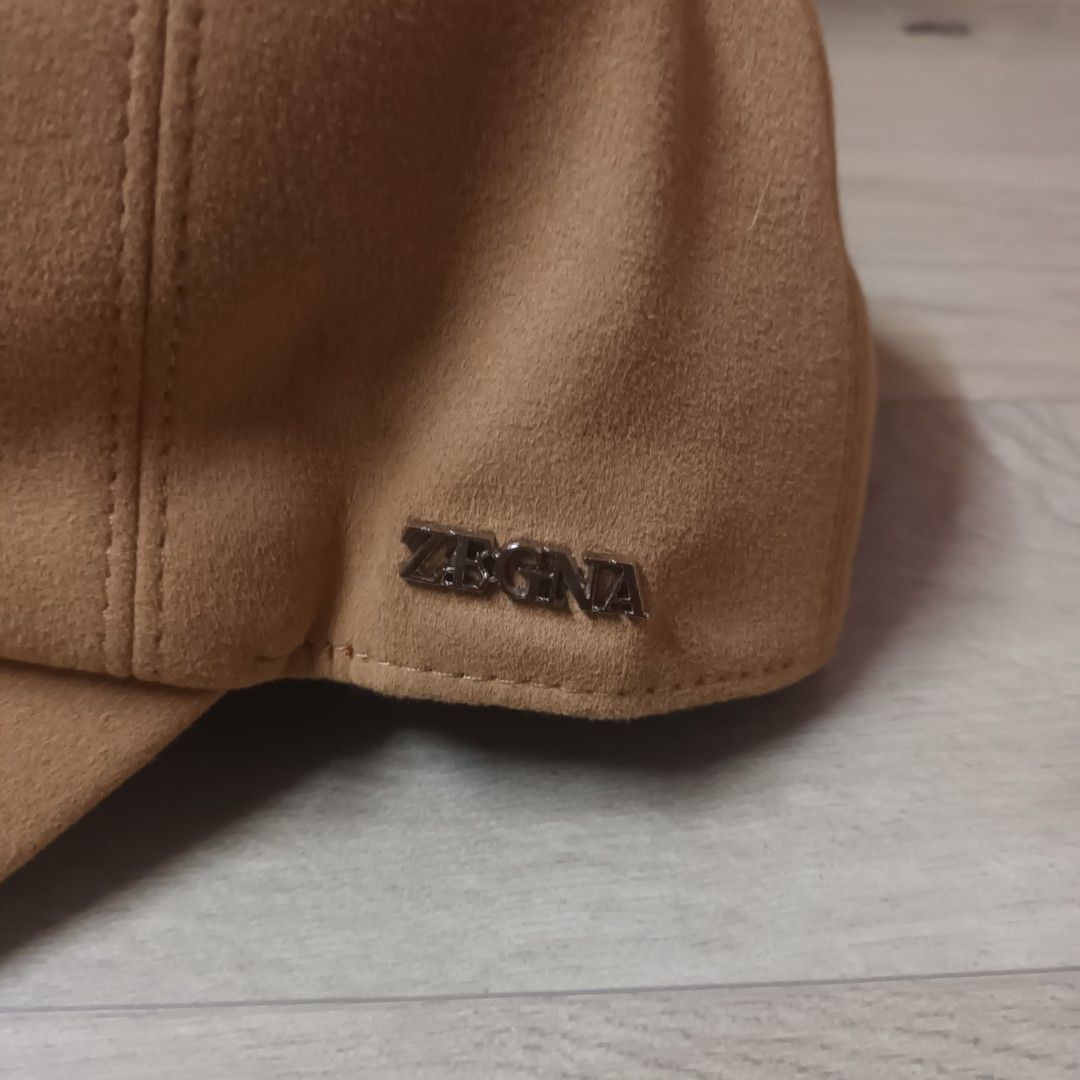 Zegna Zephyr Tan Suede Baseball Cap (Category: Caps & Hats) located in Manila. Submitted by itsnik444 (Listing ID 1470603815, Image 2). Description: - Brand: Zegna Zephyr - Material: Premium tan suede with grey inner lining and brown band - Details: Metal Zegna logo plaque on the side panel - Design: Clean shape, curved brim - Condition: Excellent, well-maintained - Style: Versatile neutral tone, great for casual everyday wear.