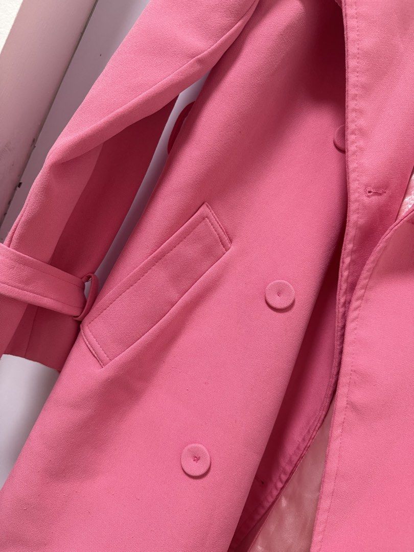 ZOMIO Pink Trench Coat Size M (Category: Coats, Jackets and Outerwear) located in Quezon City. Submitted by lovedbymaxandmikoy (Listing ID 1470678202, Image 2). Description: - Brand: ZOMIO - Size: M - Color: Bright pink - Closure: Double-breasted button front with matching waist belt - Features: Long sleeves with adjustable cuff straps, side pockets, and smooth satin lining - Condition: Great pre-loved condition - Perfect statement piece to brigh