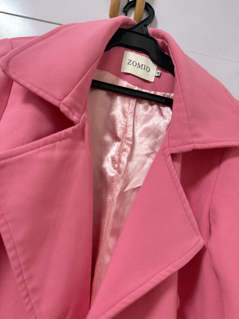 ZOMIO Pink Trench Coat Size M (Category: Coats, Jackets and Outerwear) located in Quezon City. Submitted by lovedbymaxandmikoy (Listing ID 1470678202, Image 3). Description: - Brand: ZOMIO - Size: M - Color: Bright pink - Closure: Double-breasted button front with matching waist belt - Features: Long sleeves with adjustable cuff straps, side pockets, and smooth satin lining - Condition: Great pre-loved condition - Perfect statement piece to brigh