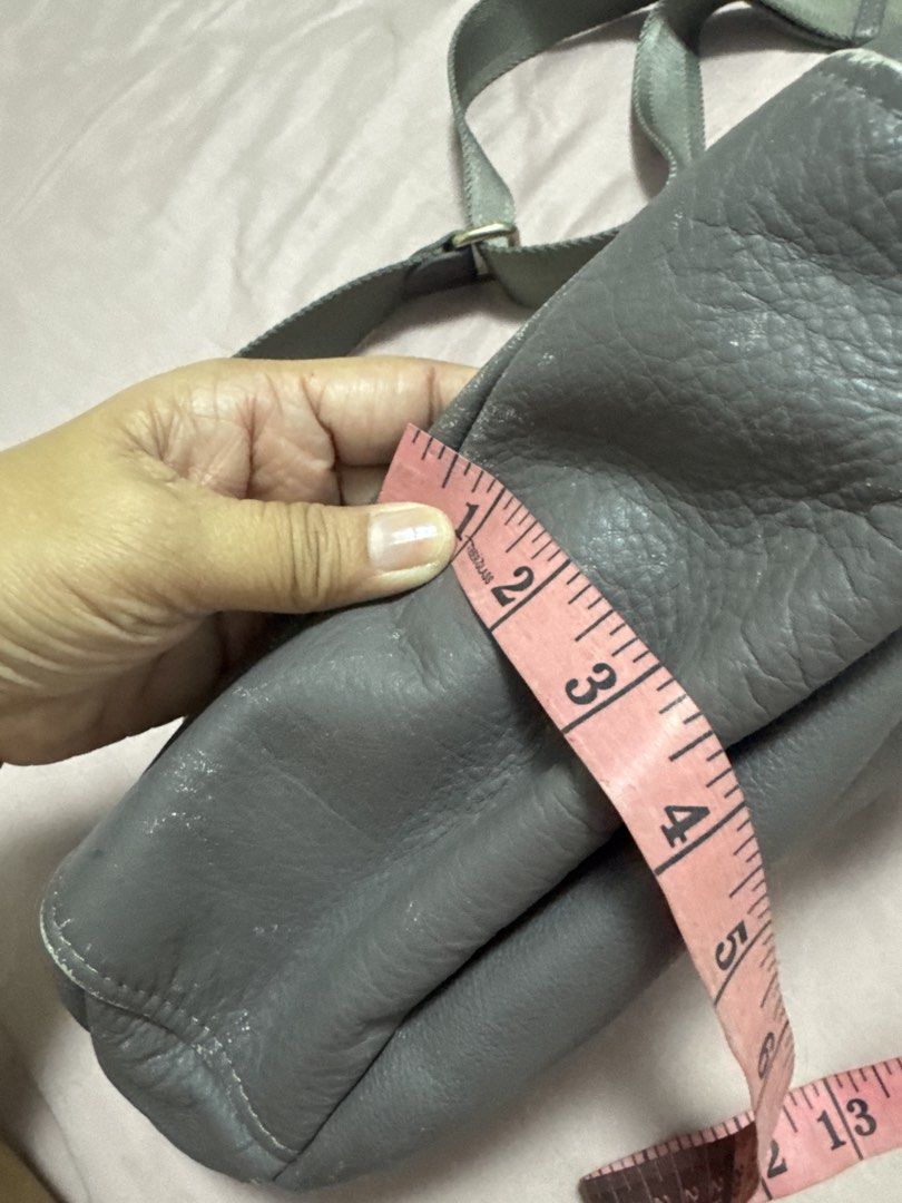 2027 BD Russet grey leather shoulder bag with adjustable strap (Category: Shoulder Bags) located in Silang. Submitted by sari2bilina (Listing ID 1470885798, Image 3). Description: Grey leather shoulder bag from Russet. Measures roughly 9 inches by 15 inches with about 4 inches width. Outer material is genuine textured leather with visible scuffs and wear along the bottom edges and corners. Zip top closure opens to a patterned dark fabric lining a