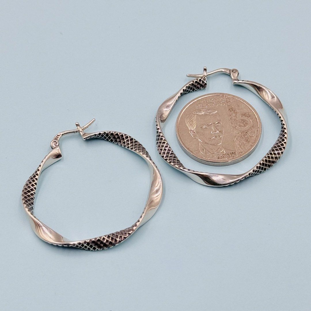 925 Silver Textured Twist Hoop Earrings (Category: Earrings) located in Baguio. Submitted by paatttyyyy (Listing ID 1470910396, Image 2). Description: - Material: Solid 925 sterling silver with official hallmark stamp - Design: Twisted hoop with a detailed textured scale pattern - Closure: Secure clasp for comfortable, all-day wear - Finish: Clean and polished for a brilliant shine - Condition: Brand new, ready to ship or meet up!.
