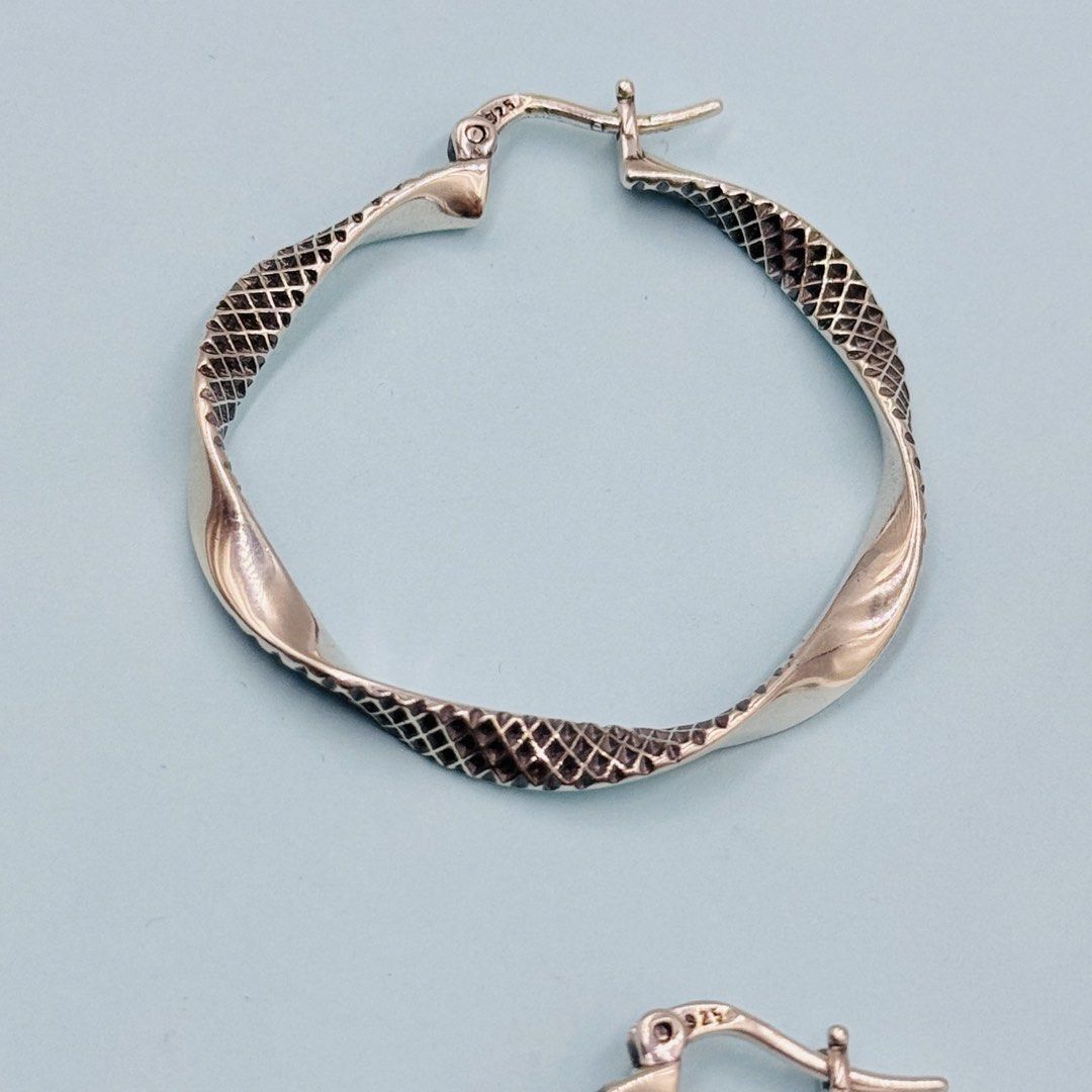 925 Silver Textured Twist Hoop Earrings (Category: Earrings) located in Baguio. Submitted by paatttyyyy (Listing ID 1470910396, Image 3). Description: - Material: Solid 925 sterling silver with official hallmark stamp - Design: Twisted hoop with a detailed textured scale pattern - Closure: Secure clasp for comfortable, all-day wear - Finish: Clean and polished for a brilliant shine - Condition: Brand new, ready to ship or meet up!.