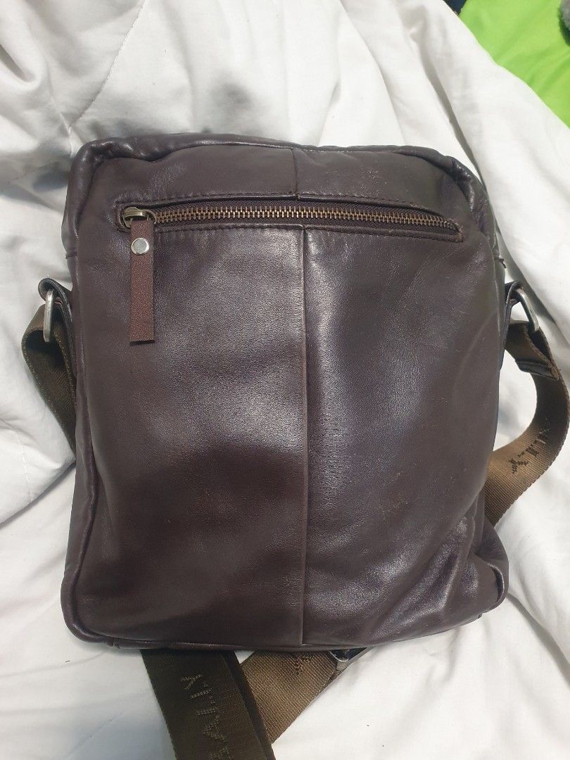💯% AUTHENTIC Bally Brown Leather Crossbody Messenger Bag (Category: Luxury Bags & Wallets) located in Marikina City. Submitted by dust.end.bags (Listing ID 1469608671, Image 2). Description: - Brand: Bally - Material: Premium brown leather - Design: Perforated front panels with iconic white and dark brown central stripe - Strap: Adjustable olive green branded webbed shoulder strap - Pockets: Front zipper pocket with Bally logo crest badge - Clos