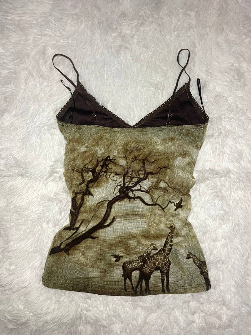 ✨ Y2K Dolls Giraffe Print Mesh Camisole ✨ (Category: Sleeveless) located in Tambulig. Submitted by vestraarchives. (Listing ID 1470808774, Image 2). Description: Vintage "Dolls" brand mesh cami with a gorgeous, moody African savanna scenic print. Features an empire waist fit, dainty spaghetti straps, and delicate black lace trim. Perfect for layering or wearing on its own..