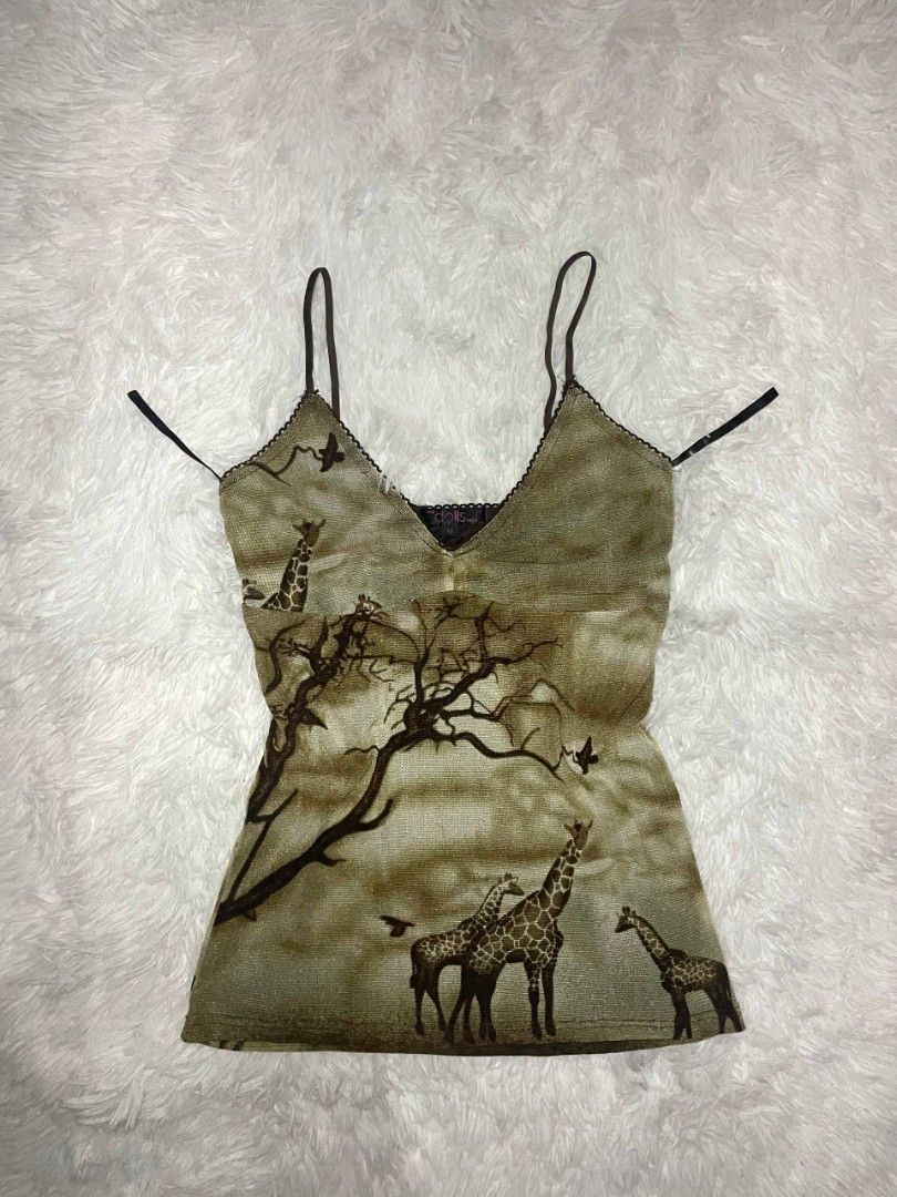 ✨ Y2K Dolls Giraffe Print Mesh Camisole ✨ (Category: Sleeveless) located in Tambulig. Submitted by vestraarchives. (Listing ID 1470808774, Image 1). Description: Vintage "Dolls" brand mesh cami with a gorgeous, moody African savanna scenic print. Features an empire waist fit, dainty spaghetti straps, and delicate black lace trim. Perfect for layering or wearing on its own..