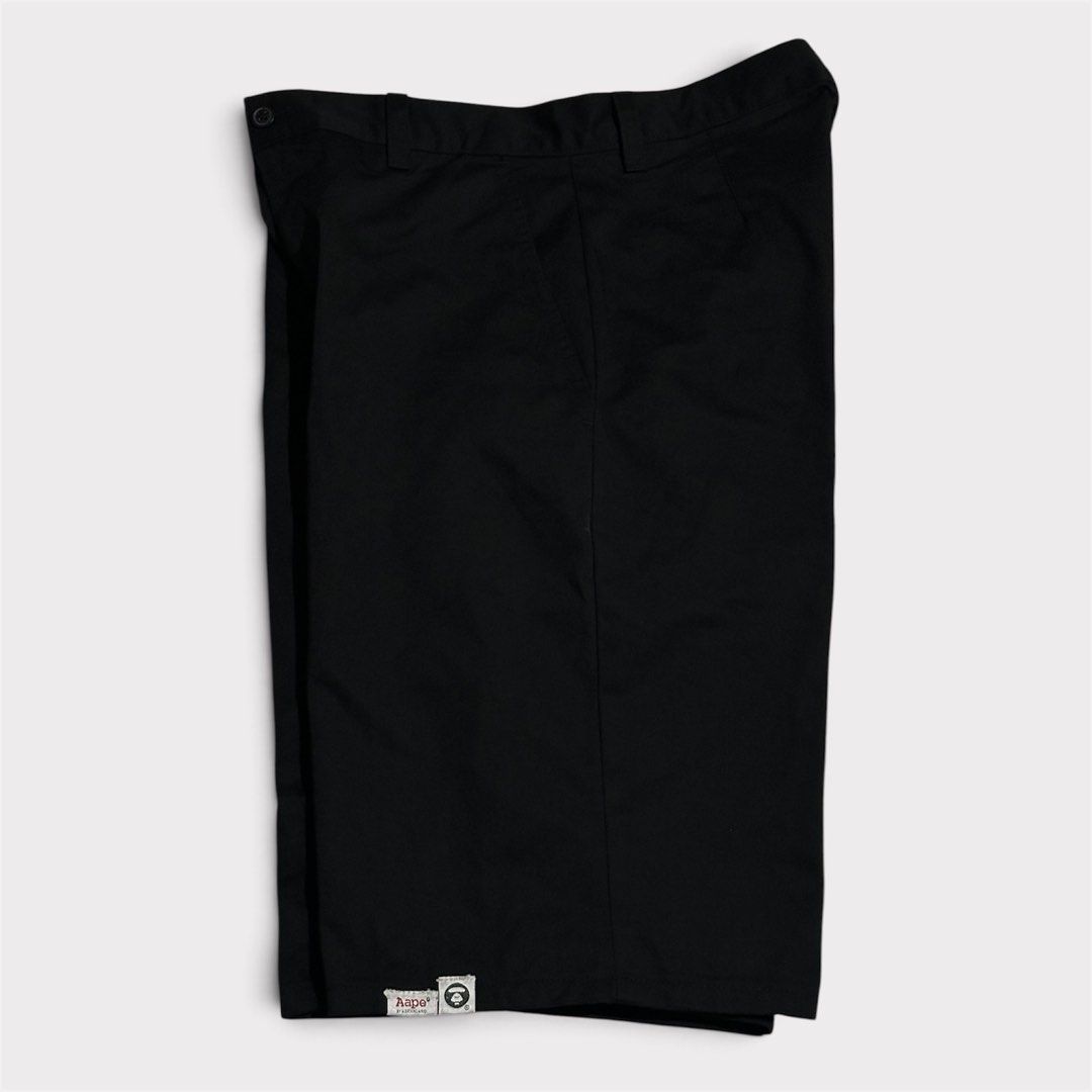 Aape Black Shorts (Category: Shorts) located in Manila. Submitted by jeproxthrift (Listing ID 1470922853, Image 2). Description: - Brand: Aape - Color: Black (Solid) - Style: Casual streetwear, straight leg cut - Features: Belt loops, front button closure, deep side pockets - Detail: Small woven Aape logo patch near bottom hem - Condition: Excellent / Clean throughout.