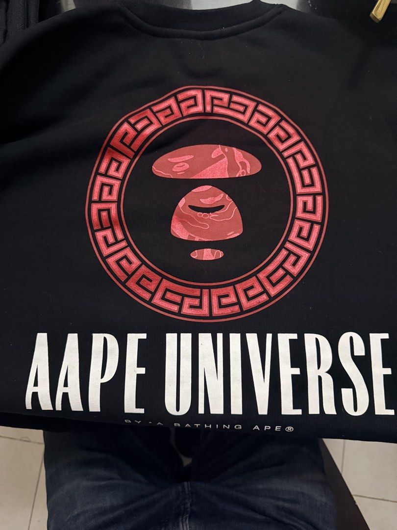 Aape by A Bathing Ape Black Sweatshirt (Category: Coats, Jackets and Outerwear) located in Caloocan City. Submitted by ninomendoz48209 (Listing ID 1470832439, Image 2). Description: - Brand: Aape by A Bathing Ape - Color: Black - Size: Small (S) - Design: Front text with red chest graphic, large Aape Universe back graphic inside a red circle - Details: Branded inner collar taping and original wash care tags intact - Condition: 100% authentic, wel