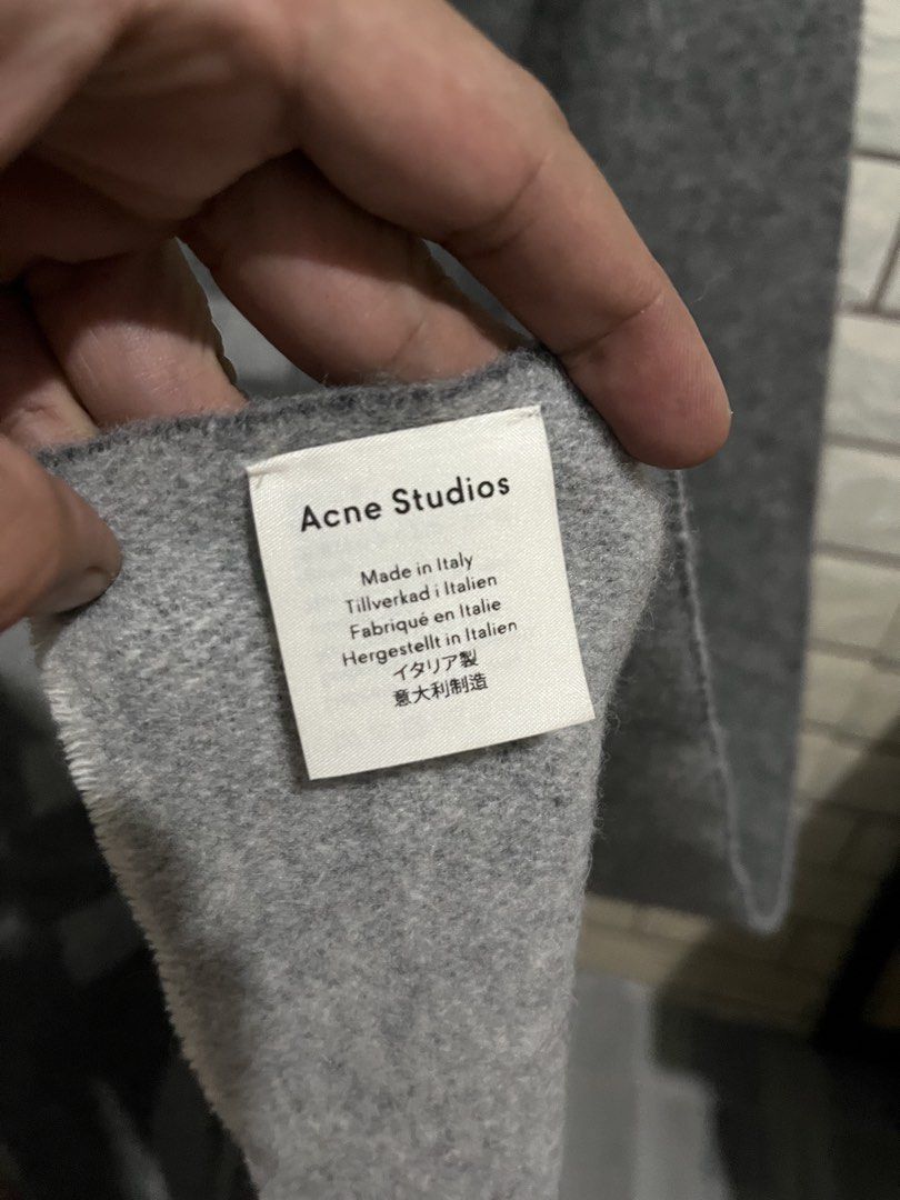 Acne Studios Grey Logo Scarf (Category: Scarves) located in Manila. Submitted by kuya_erick62 (Listing ID 1470760564, Image 3). Description: - Brand: Acne Studios - Color: Dark grey with contrasting light grey text graphic - Material: 80% wool, 20% nylon blend - Origin: Made in Italy - Dimensions: 220 x 50 cm - Condition: Brand new with tag attached - Care: Delicate dry clean only.